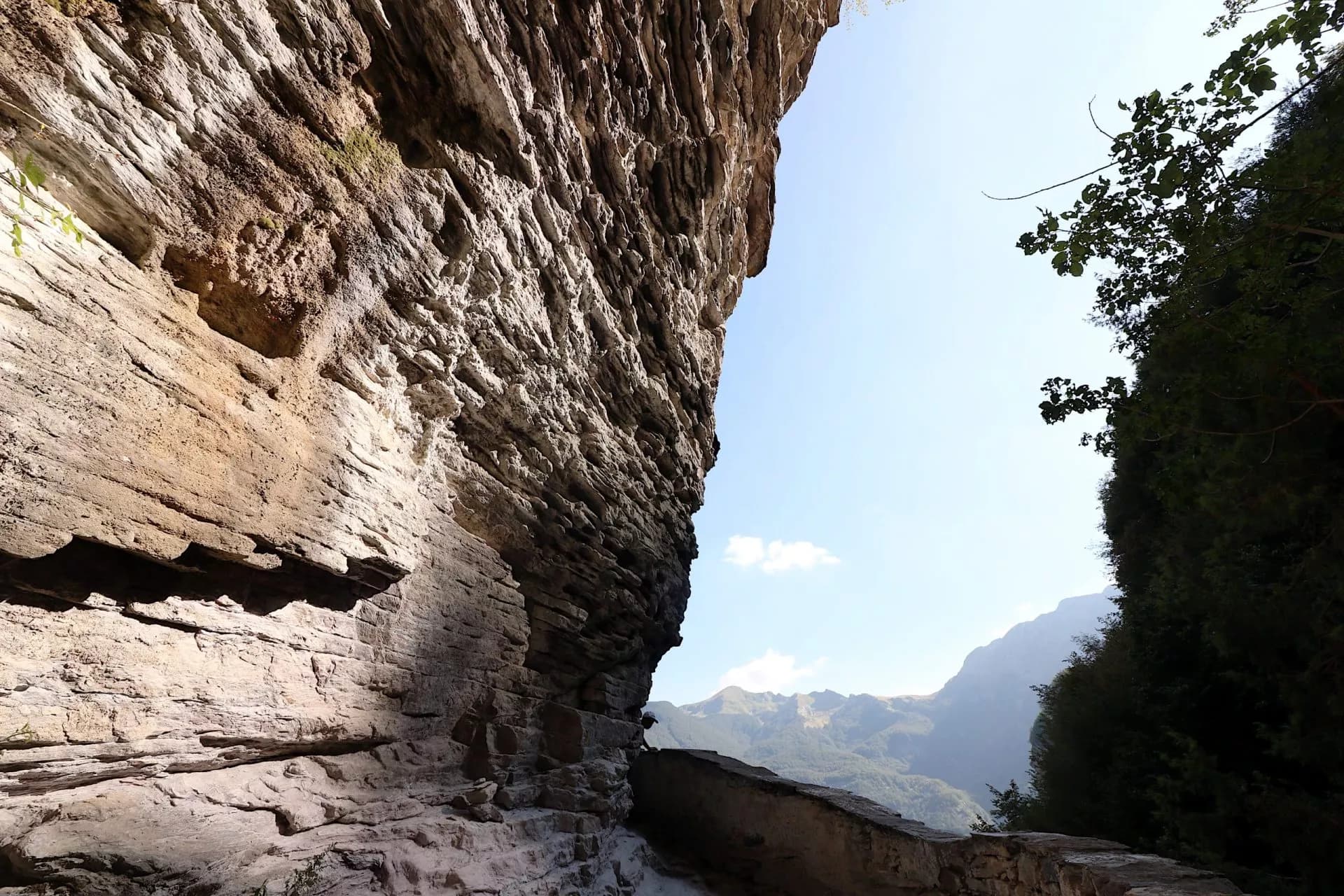 Path carved into cliff face near San Vivianos Hermitage overlooking hazy mountains.