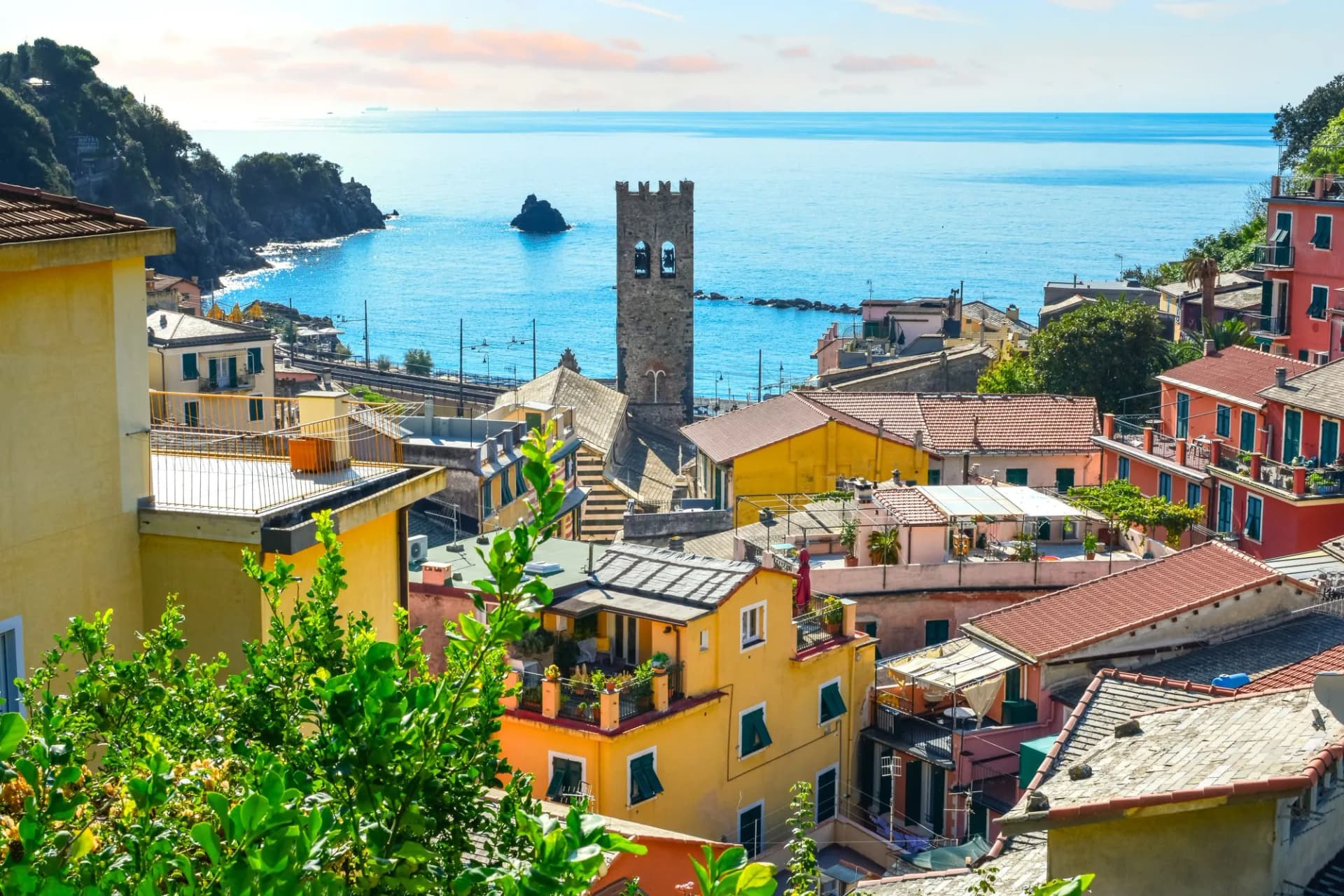 Coastal town with colorful houses, stone bell tower, and the blue Ligurian Sea from Monterosso al Mare.