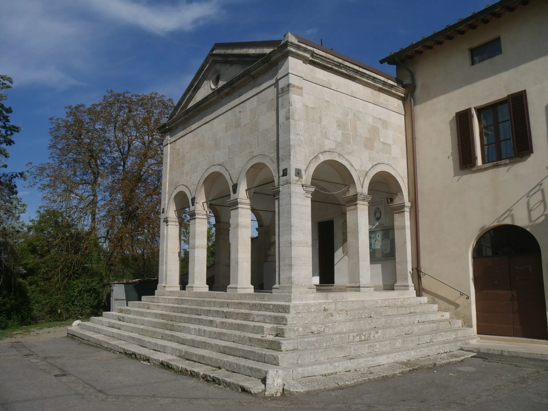 St. Martial church in Gracciano dell'Elsa has the facade with the raised entrance with a nineteenth-century loggia